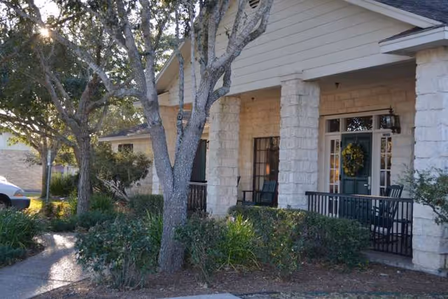 Front entrance of College Place Assisted Living with porch, chairs, and wreath.