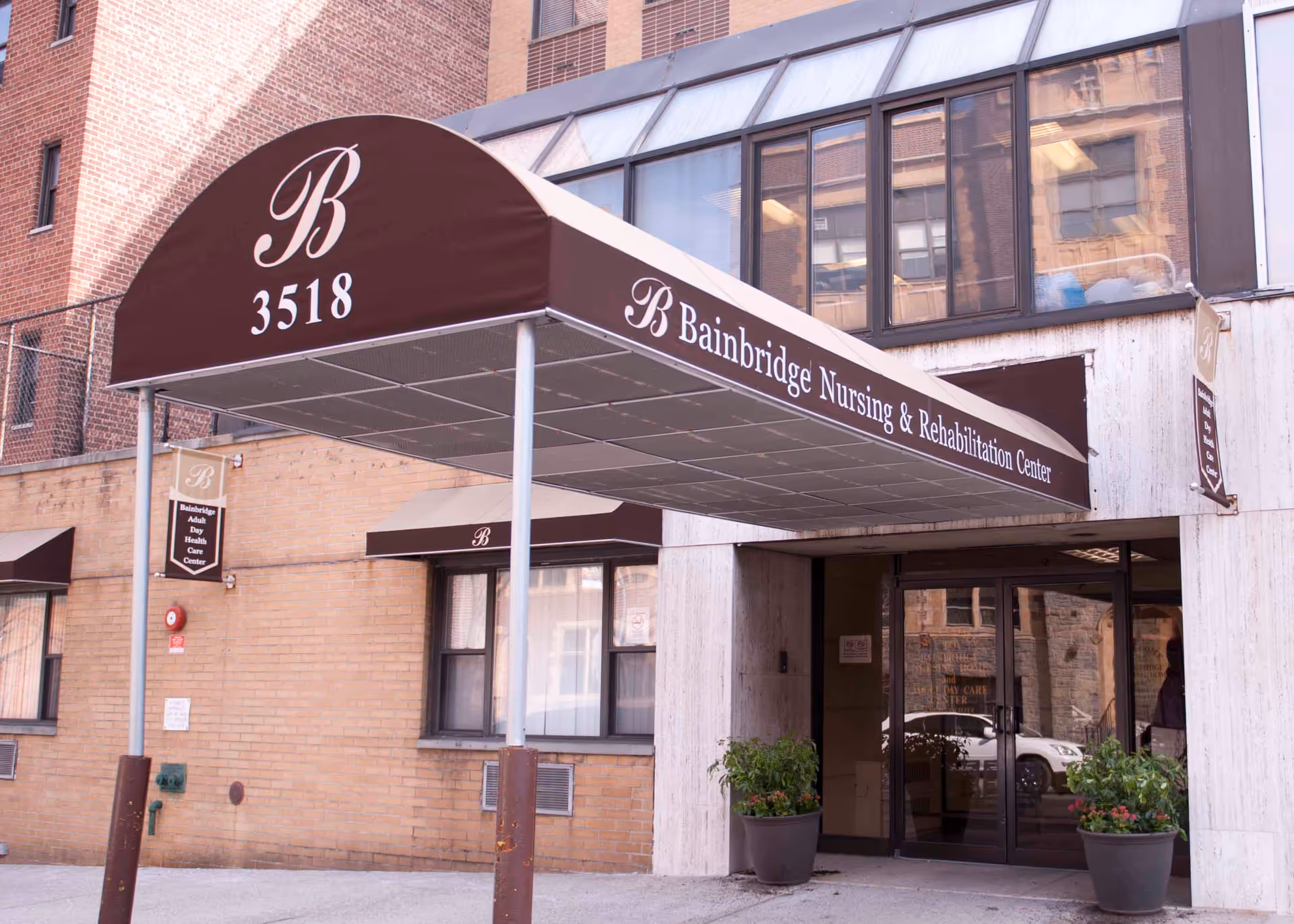 Covered maroon awning reading 'Bainbridge Nursing & Rehabilitation Center' and '3518' over the entrance to a brick nursing home.