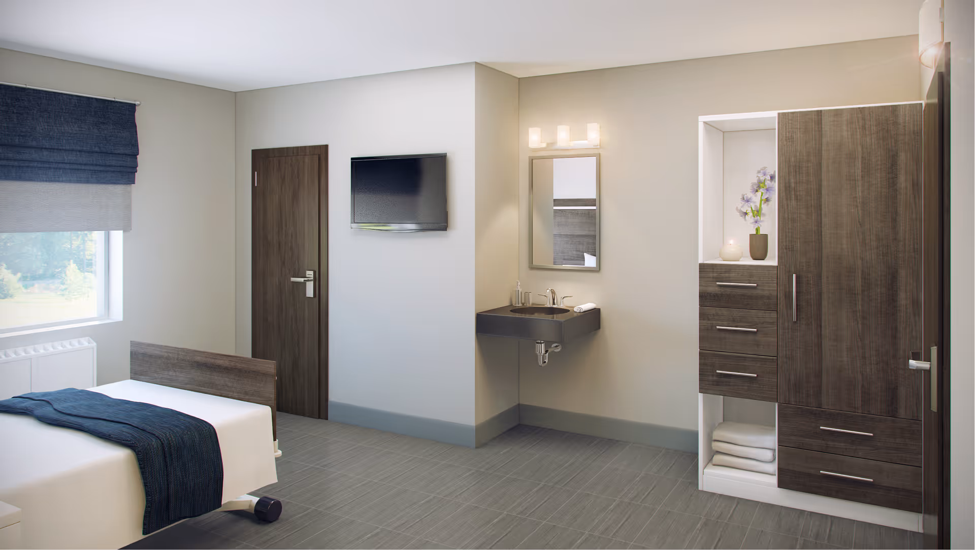 A clean and modern bedroom in a senior living facility with a single bed covered with white sheets and a dark blue blanket. There is a window with a blue roman shade, a wall-mounted flat-screen TV, a wooden door, a wall-mounted sink with a mirror and light above it, and a wooden wardrobe with drawers and shelves containing towels and a vase with flowers.