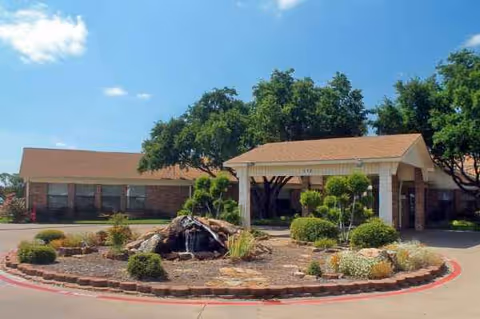 Exterior view of Carriage House Manor with a circular driveway and landscaped entrance.