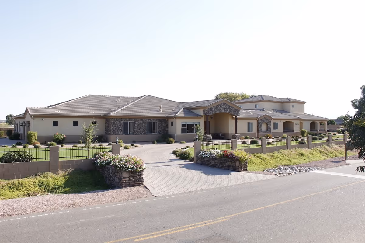 Moonlight Manor senior living facility exterior with driveway, stone planters, and manicured lawn.