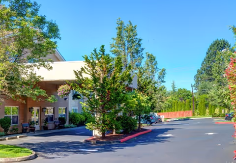 Exterior view of Princeton Village by Cogir with a driveway, trees, and parked cars.