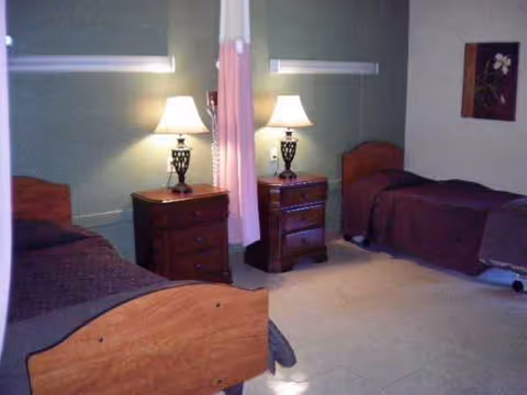 Two single beds with nightstands and lamps in a shared bedroom.