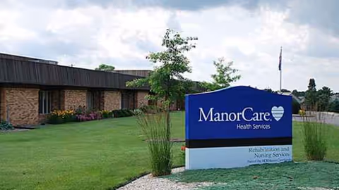 Exterior view of a senior care facility with a blue ManorCare sign.