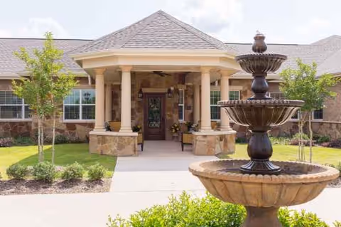 Entrance to Autumn Leaves Georgetown senior living facility with a fountain and landscaped walkway.