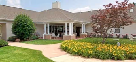 Exterior view of Brookdale Harrisonburg with a covered entrance and landscaped garden.