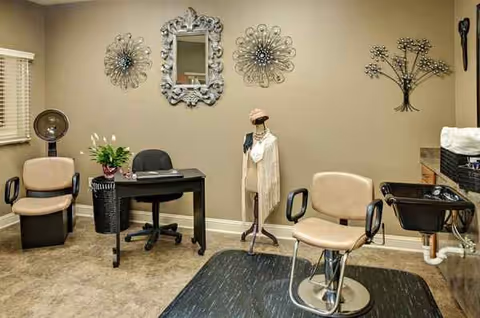 Small salon area with chairs, a mirror, mannequin, and hair styling equipment.
