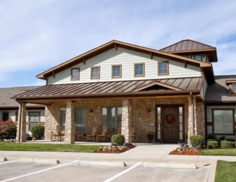 Exterior view of Martin Crest Assisted Living and Memory Care building with stone facade and entry.