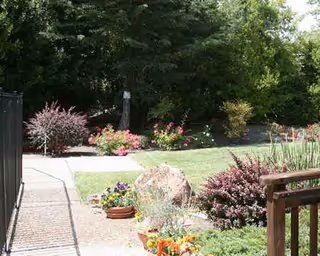 A well-kept garden with a brick path and colorful flowers outside a building.