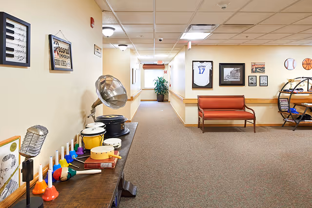 A brightly lit interior hallway with seating, a table of musical instruments and decor on the walls.