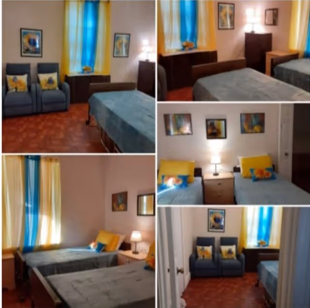 Collage of images showing a bedroom with two single beds, blue and yellow bedding, bedside tables with lamps, blue armchairs with floral cushions, colorful curtains, framed artwork on the walls, and wooden furniture.