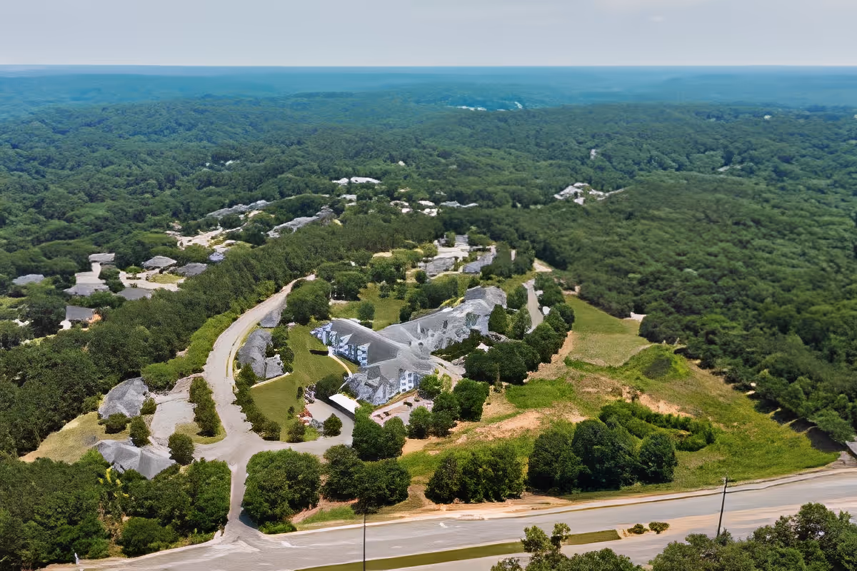 Aerial view of the TerraBella Epps Bridge senior living campus with multiple buildings, driveways, and surrounding forest.