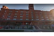 A tall red brick apartment building facade with arched windows.