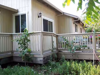 Exterior view of Mt Vernon Gardens residential care facility with a wooden porch and plants.