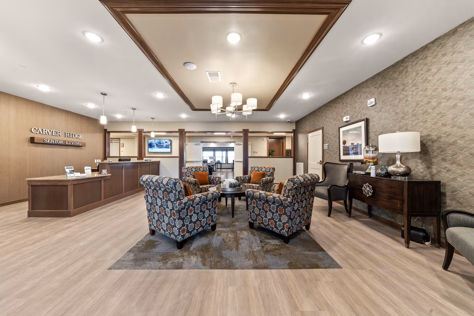 Spacious lobby of Carver Ridge Senior Living with a central seating area, reception desk, and decorative furnishings.