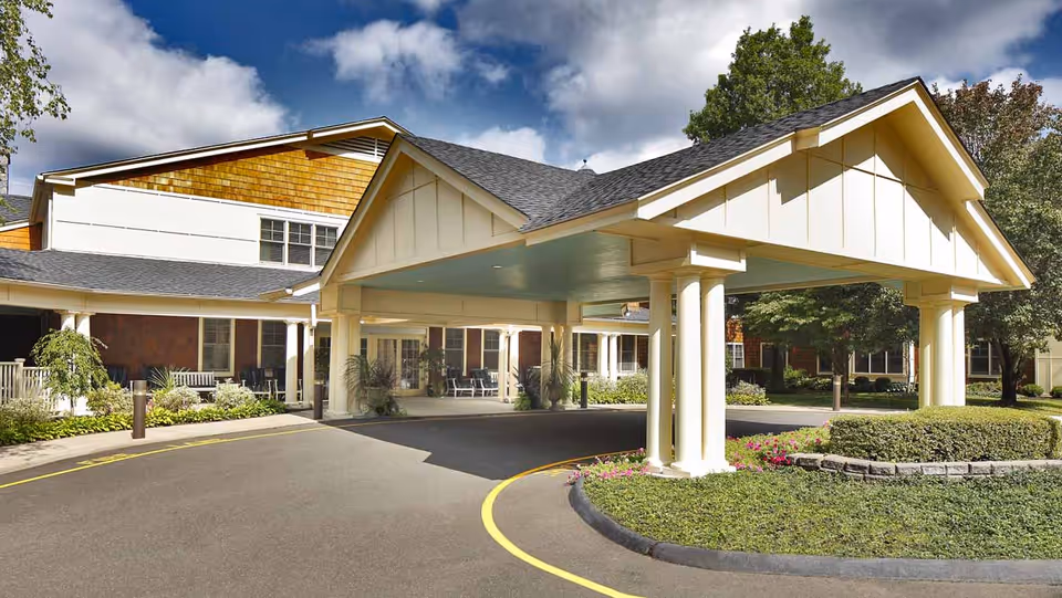 Atria Darien senior living facility exterior featuring a covered entrance and landscaped front drive.