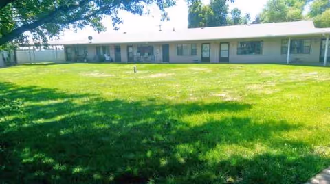 A single-story building with a wide front and a well-kept grassy lawn.
