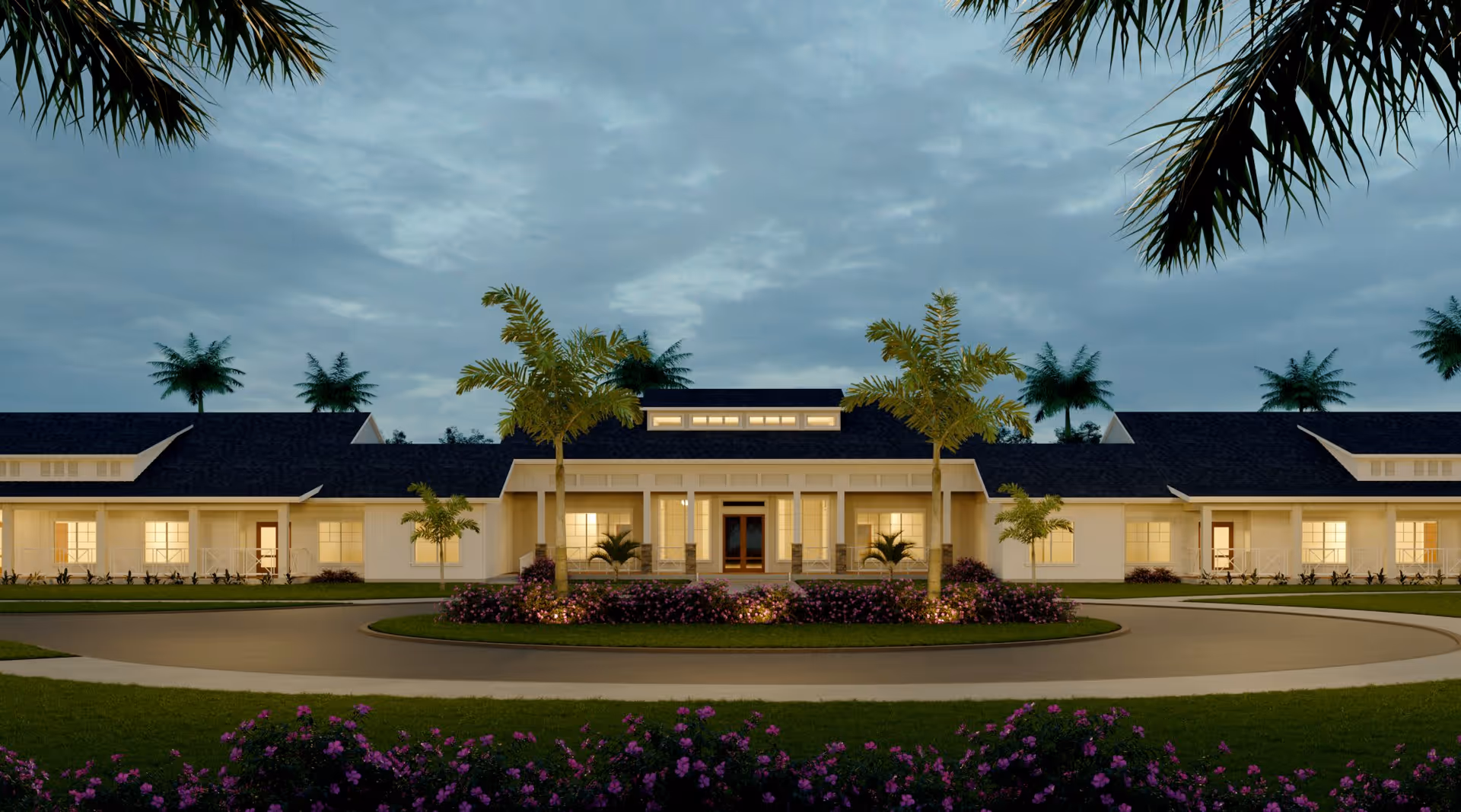 Front exterior view of a single-story senior living facility building with warm interior lights glowing through large windows, surrounded by palm trees and landscaped flower beds under a cloudy evening sky.