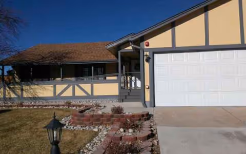 Front exterior view of Cardan Manor Assisted Living with a two car garage and entry stairs.