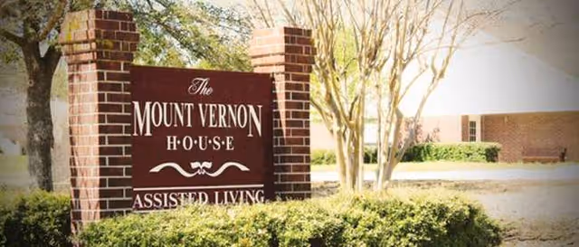 A brick sign reads The Mount Vernon House for assisted living at a building entrance.