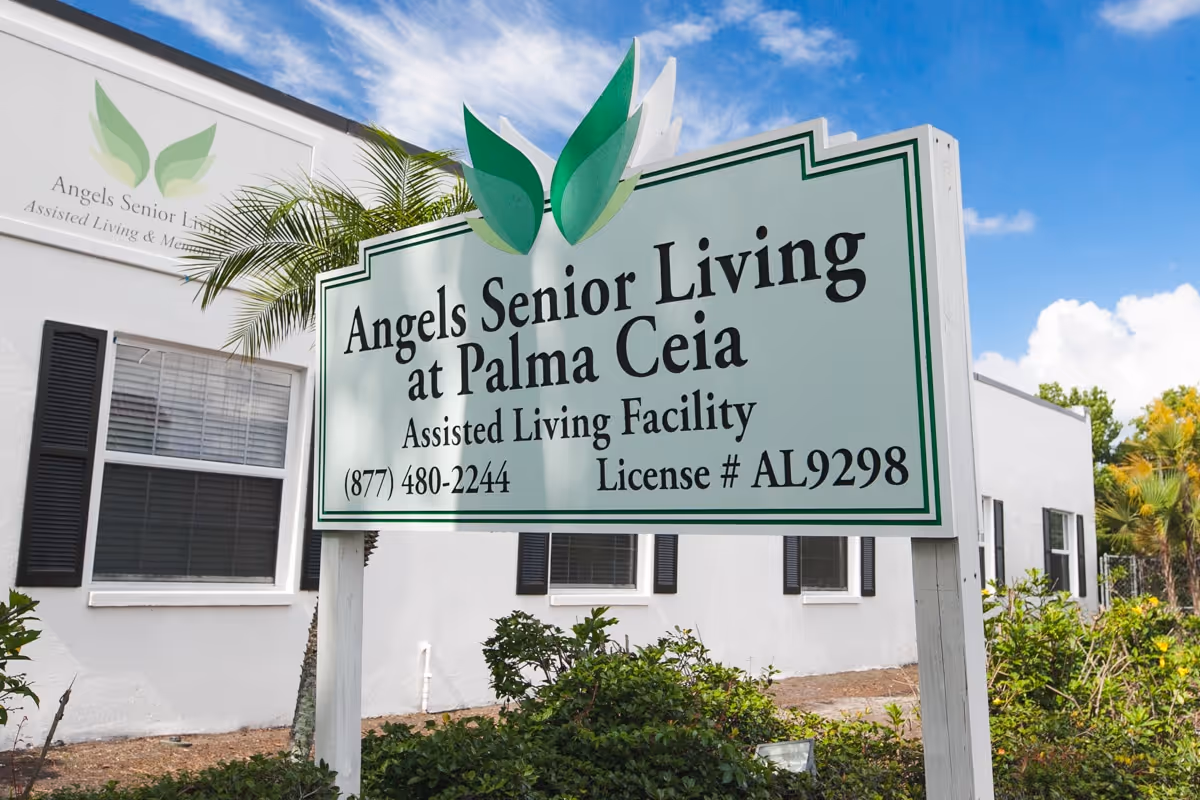 A large outdoor sign for Angels Senior Living at Palma Ceia assisted living facility standing in front of a white building.