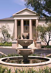 Exterior view of Peppers Estate with a columned entrance and tiered fountain.