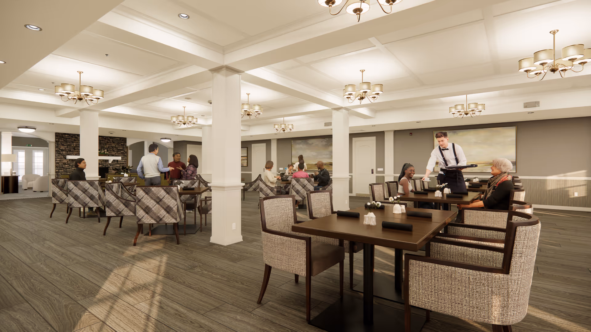A spacious and well-lit dining room in Cedar Lake Assisted Living and Memory Care with several tables and cushioned chairs. People are seated and engaged in conversation while a waiter serves food. The room features multiple chandeliers, large paintings on the walls, and a cozy atmosphere with a stone fireplace visible in the background.