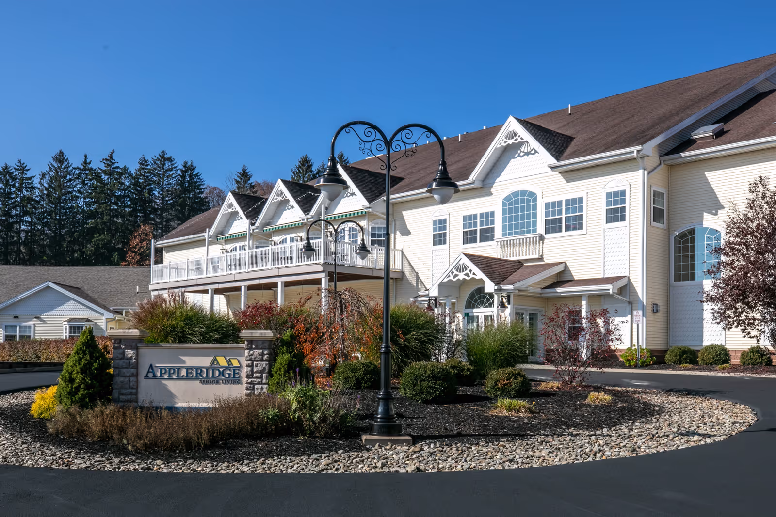 Exterior view of Appleridge Senior Living with landscaped entrance and sign.