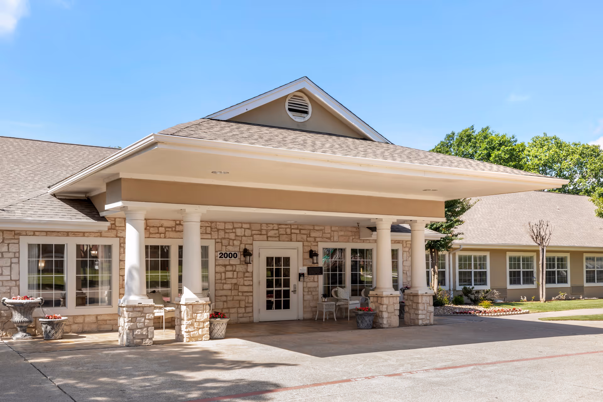 Front entrance of Brookdale Creekside with stone facade, columns, and glass doors under a covered canopy