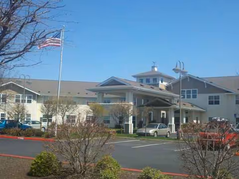 Front view of Hawks Ridge Assisted Living facility with entrance and flag.