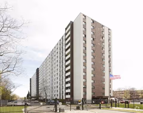 Tall River Towers senior living building with a gated entrance and flag in front.