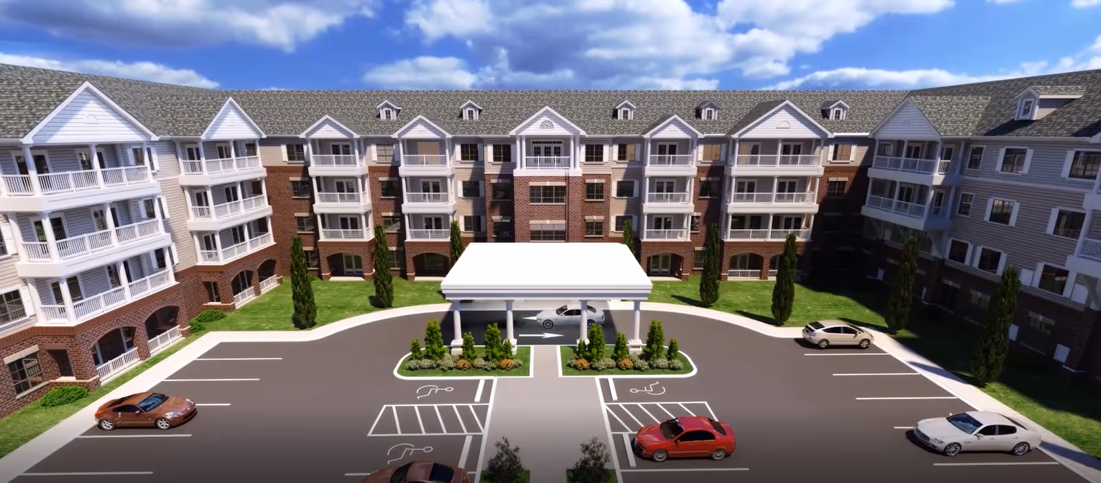 Exterior front view of a multi-story senior living building with balconies, a covered porte-cochere entrance, landscaped center island, and surrounding parking lot.