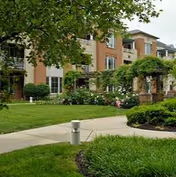 Exterior view of Kirkland Village building with brick facade, lawn, and landscaped walkway.