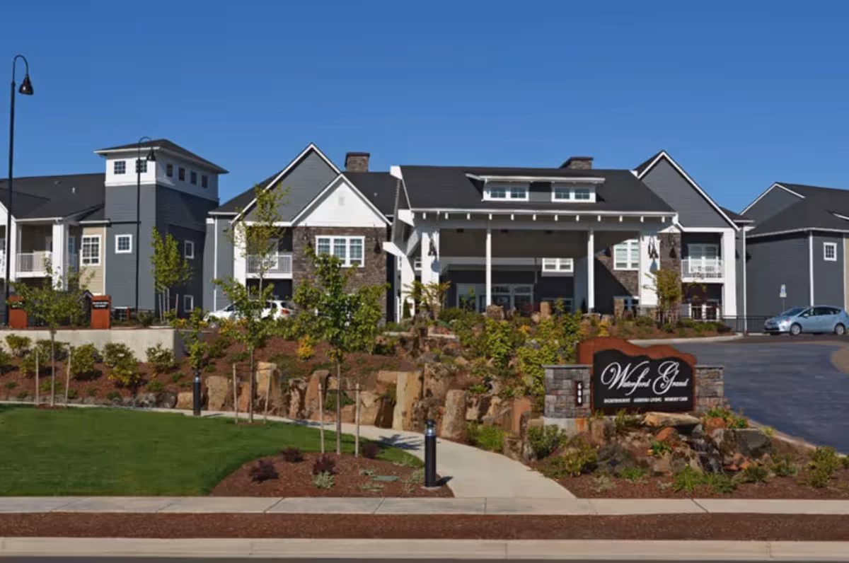Exterior front view of the Waterford Grand senior living building with landscaped grounds and entrance sign.