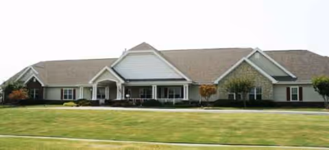 Long, single-story senior living facility with a manicured lawn and front entryway.
