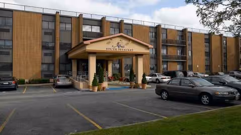 Exterior view of The Village at South Setauket entrance with parked cars.