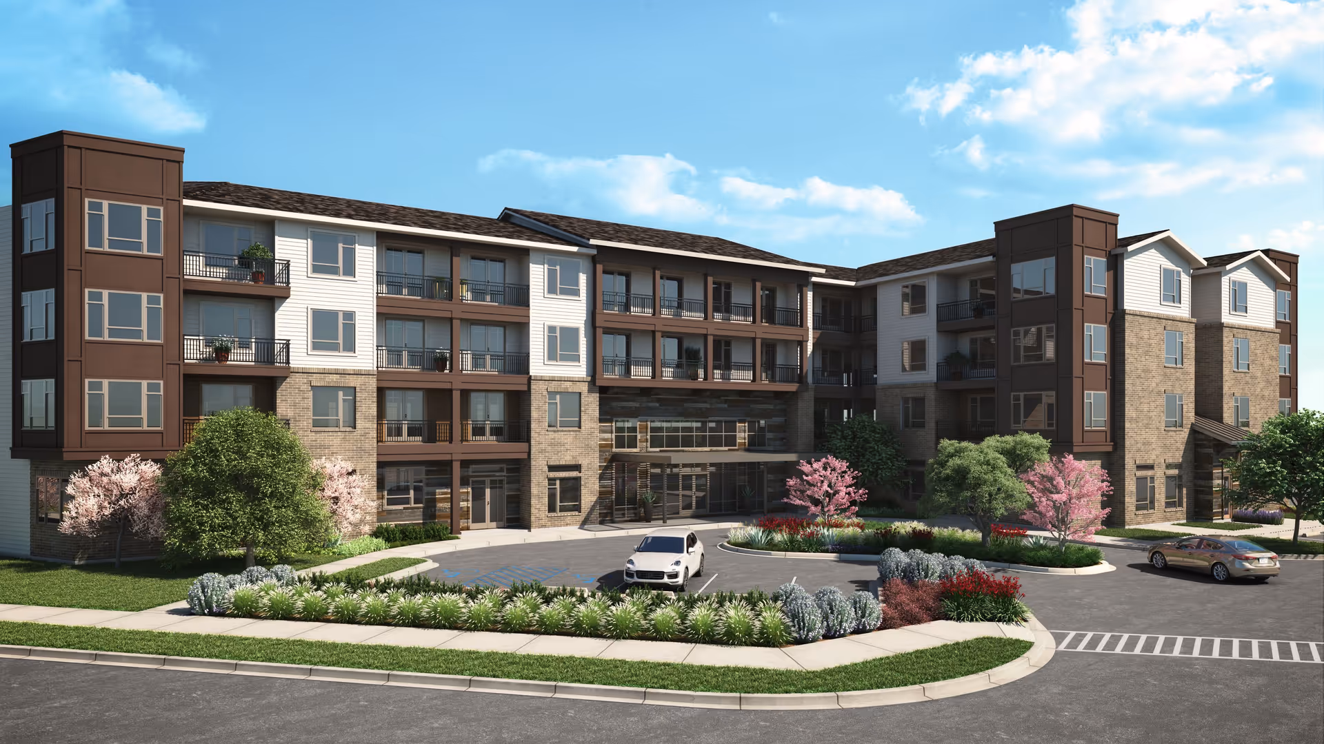 Four-story residential building front with balconies, landscaped circular driveway and parked cars under a blue sky.