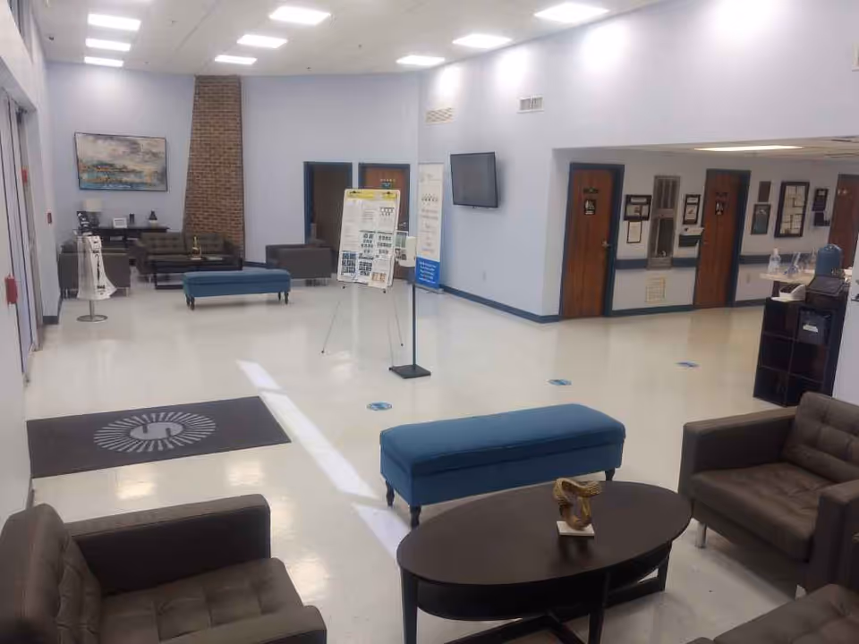 Spacious lobby seating area with couches, benches, a coffee table and informational display boards.