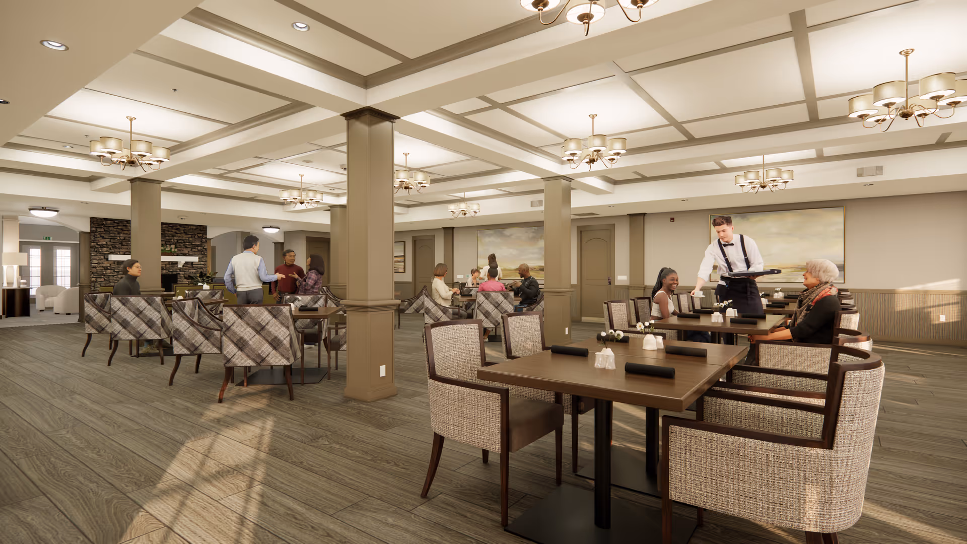 A spacious senior living dining room with multiple tables and cushioned chairs. Several seniors are seated and engaged in conversation while a waiter serves food. The room features wooden flooring, beige walls, decorative ceiling beams, and modern chandeliers. There is a stone fireplace in the background and large paintings on the walls.