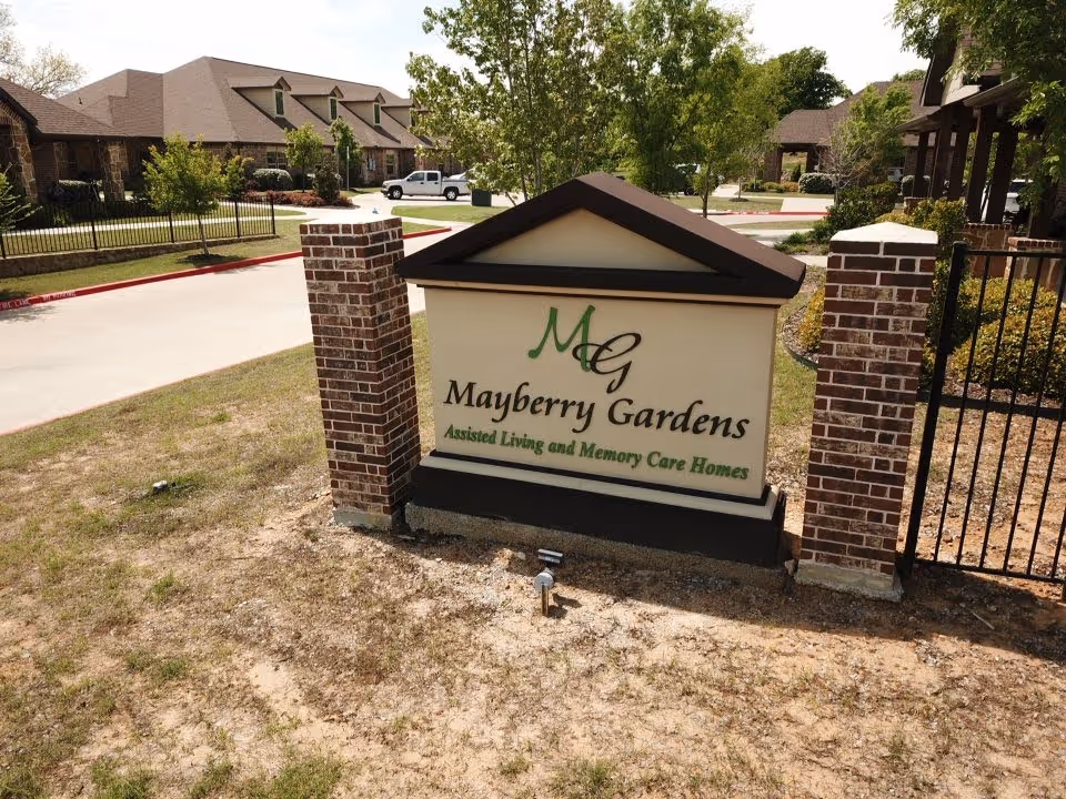 Entrance sign reading 'Mayberry Gardens Assisted Living and Memory Care Homes' in front of a residential campus.