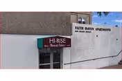 Front exterior of Faith Haven Apartments showing a white wall with 'Faith Haven Apartments' signage and a maroon 'Hi-Rise Beauty Salon' awning above an entrance.