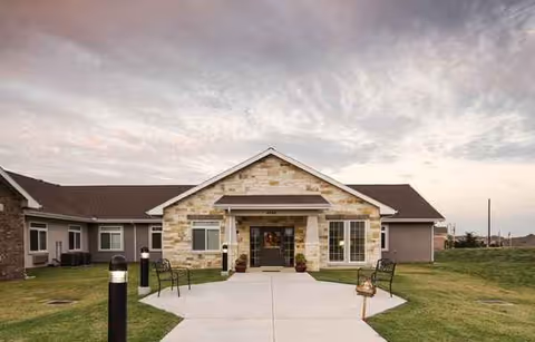 Front exterior view of Oxford Glen Memory Care at Grand Prairie with stone facade and entrance.