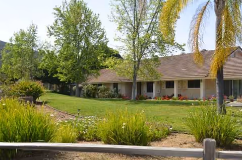 Front exterior of Daybreak Retirement Villa with manicured lawn and trees.