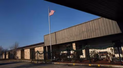 Exterior view of Patterson Healthcare Center with flagpole and entrance.
