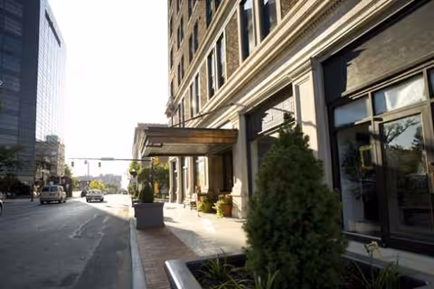Exterior view of Shawnee Place building entrance with sidewalk and planters.