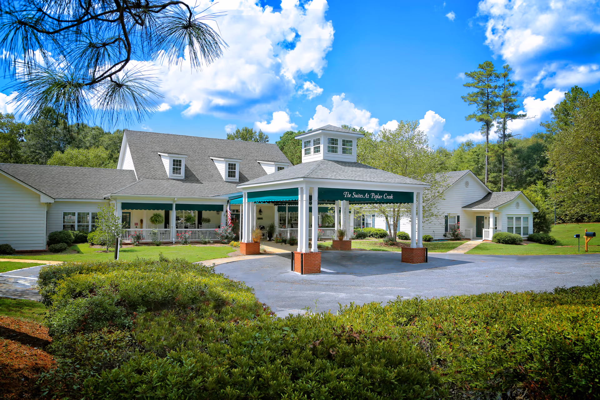 Exterior view of Poplar Creek Senior Care with a covered entrance and landscaped grounds.