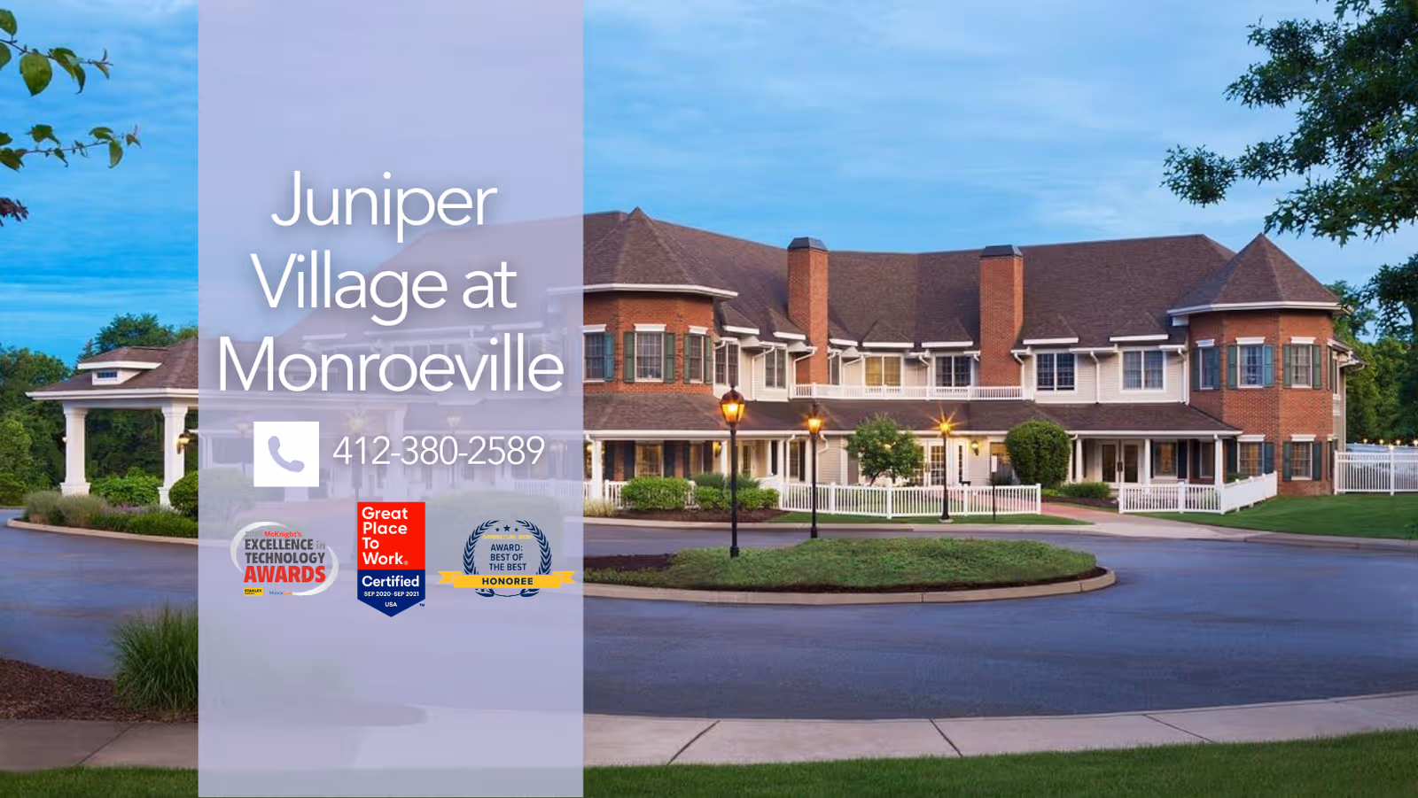 Exterior view of Juniper Village at Monroeville, a large two-story senior living facility with brick and white siding, surrounded by greenery and a circular driveway with street lamps.