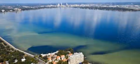 Aerial view of a large lake with buildings along the shoreline.