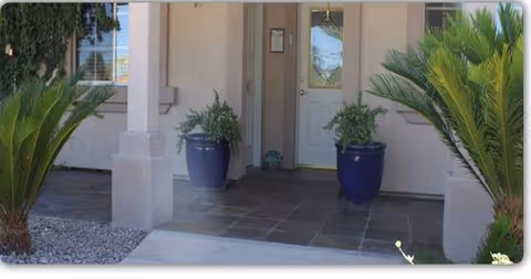 Front entrance of White Dove Assisted Living at Arrowhead with blue planters.