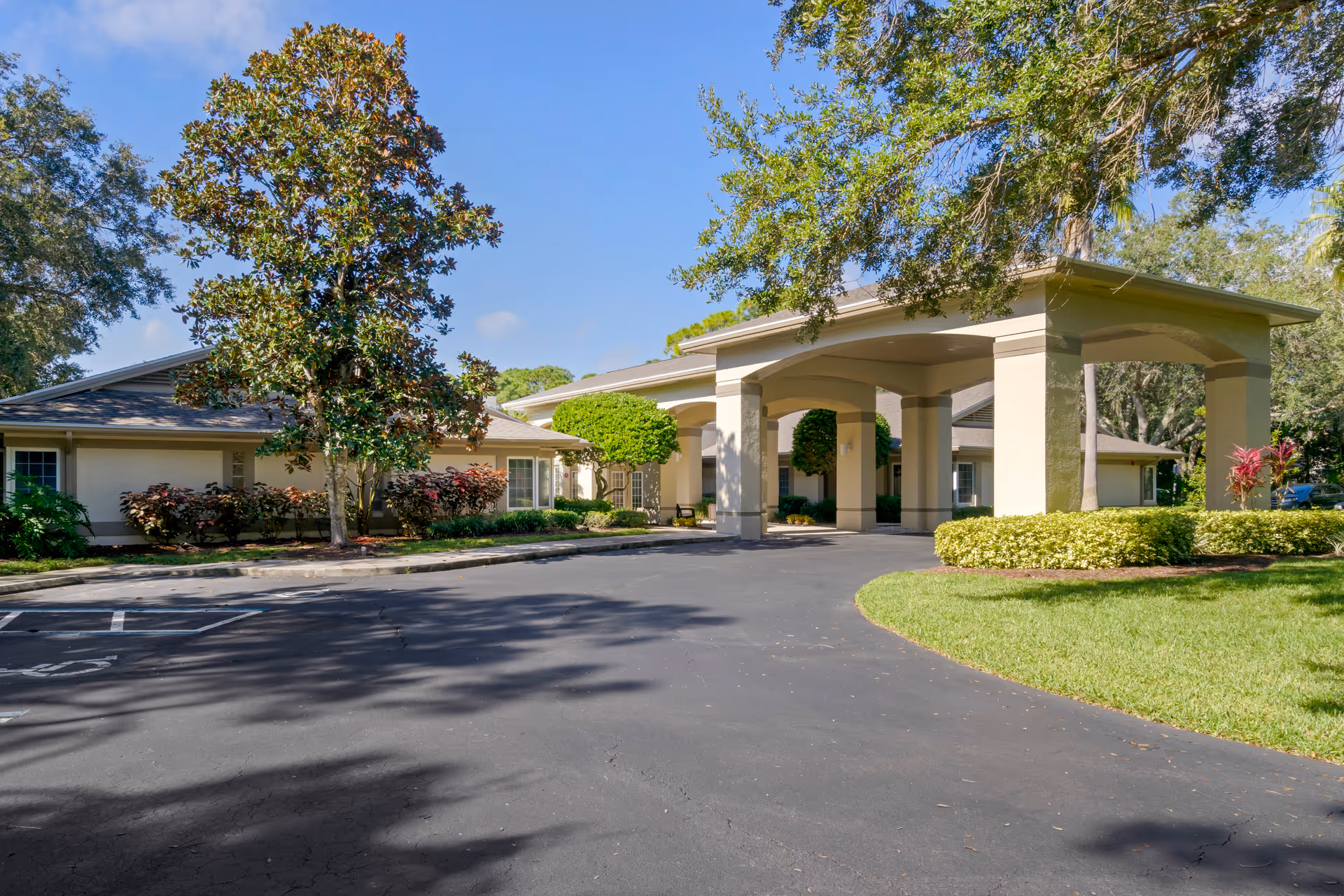 Senior living facility entrance with a porte-cochère and landscaped driveway